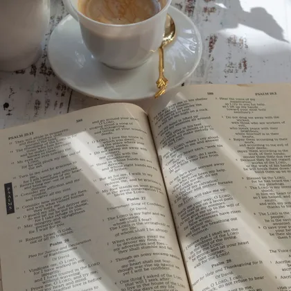 Uppslagen bibel och kaffe