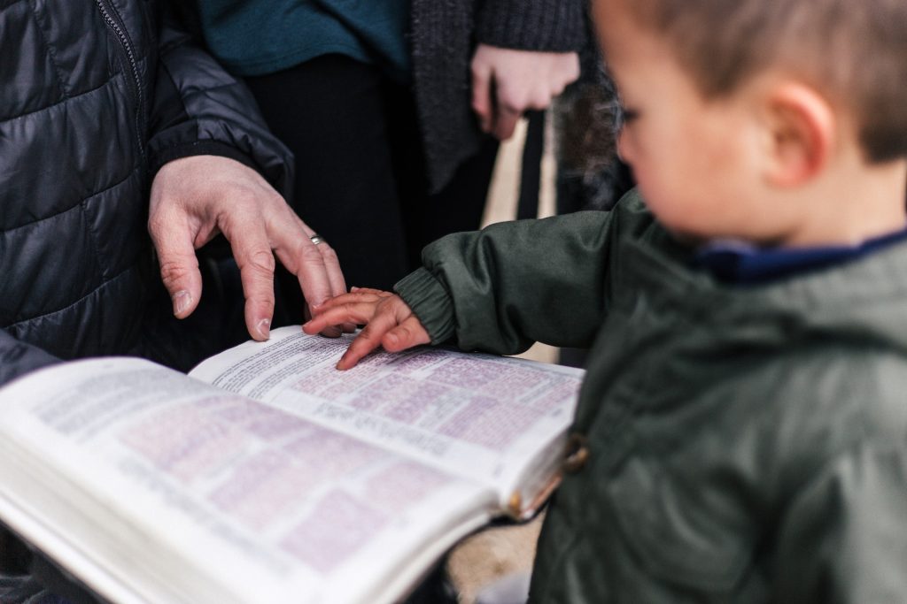 Barn som pekar i en bibel